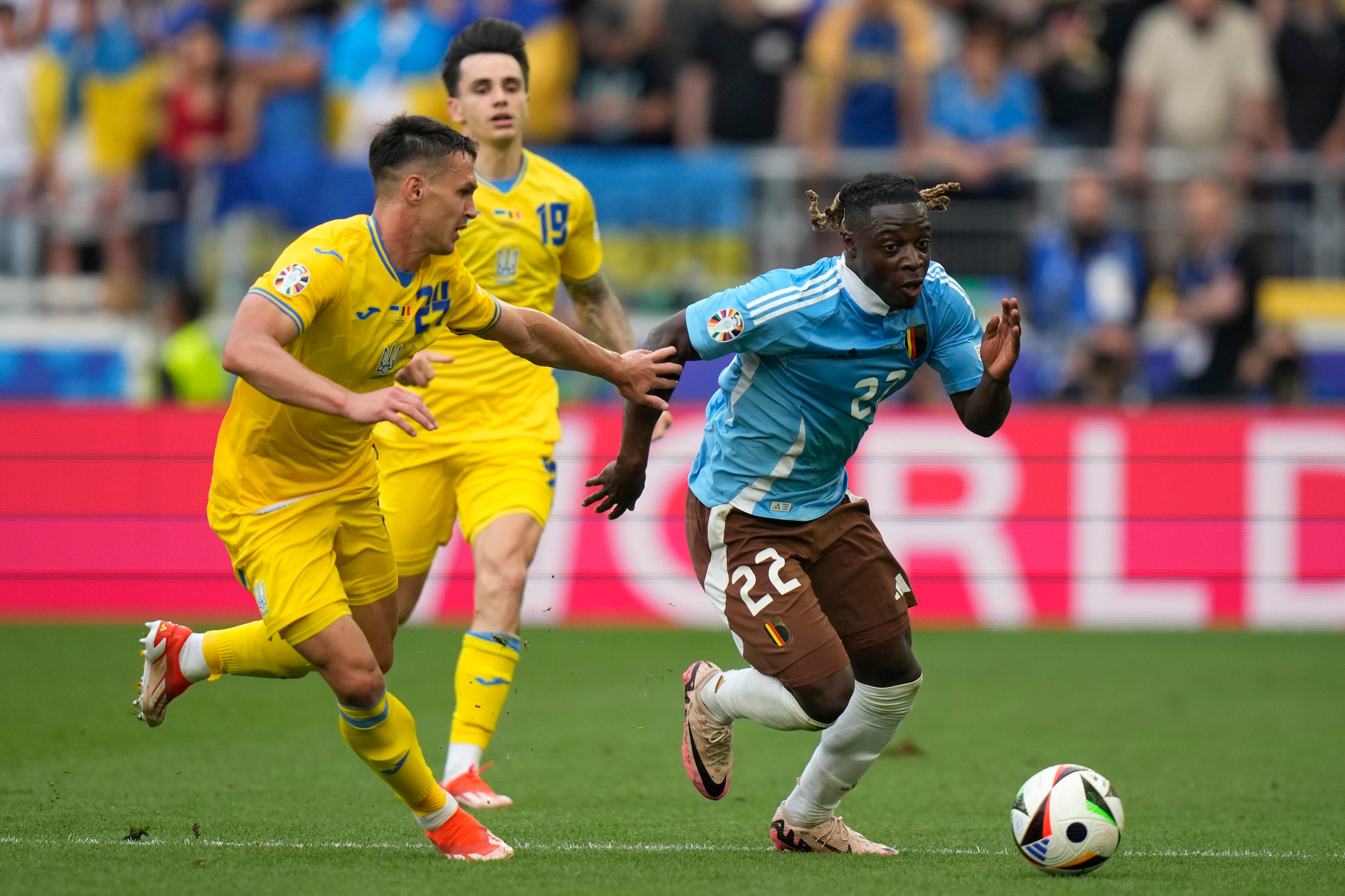 Belgium's Jeremy Doku, right, is challenged by Ukraine's Oleksandr Tymchyk during a Group E match between Ukraine and Belgium at the Euro 2024 soccer tournament in Stuttgart, Germany, Wednesday, June 26, 2024. (AP Photo/Matthias Schrader)