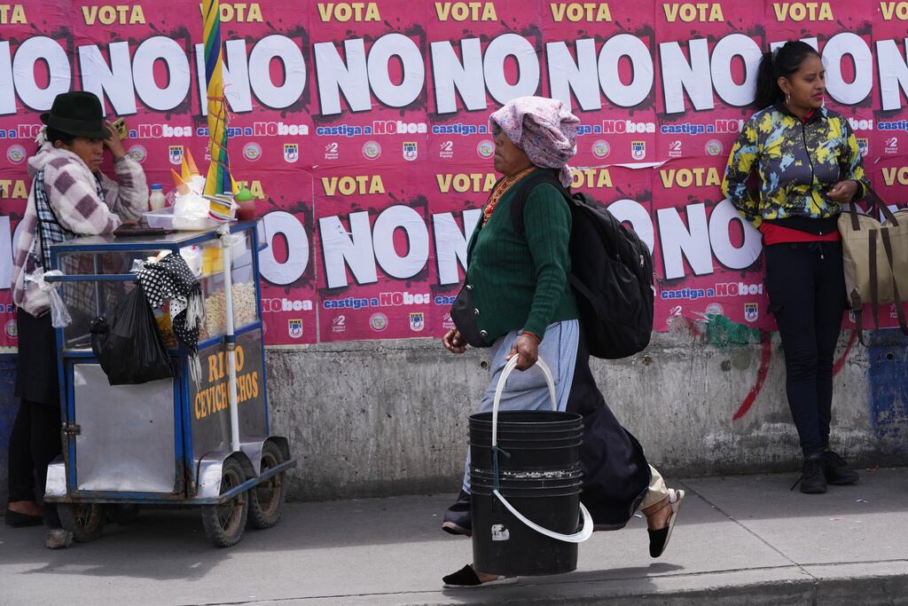 Carteles que promueven el voto por el "no" en un referéndum sobre la autorización de bases militares extranjeras y la convocatoria de una Asamblea Constituyente para redactar una nueva Constitución cubren una pared en Quito, Ecuador.