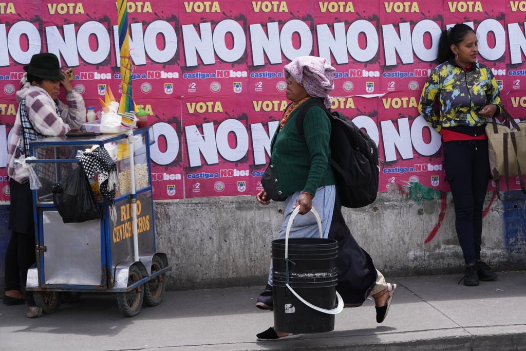 Carteles que promueven el voto por el "no" en un referéndum sobre la autorización de bases militares extranjeras y la convocatoria de una Asamblea Constituyente para redactar una nueva Constitución cubren una pared en Quito, Ecuador.