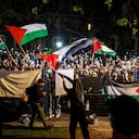 Manifestantes pro palestinos ondean banderas y sostienen teléfonos inteligentes fuera del área vallada de un campamento en el campus de la Universidad de Toronto el 2 de mayo de 2024, en Toronto, Canadá. (Foto de Cole BURSTON / AFP)