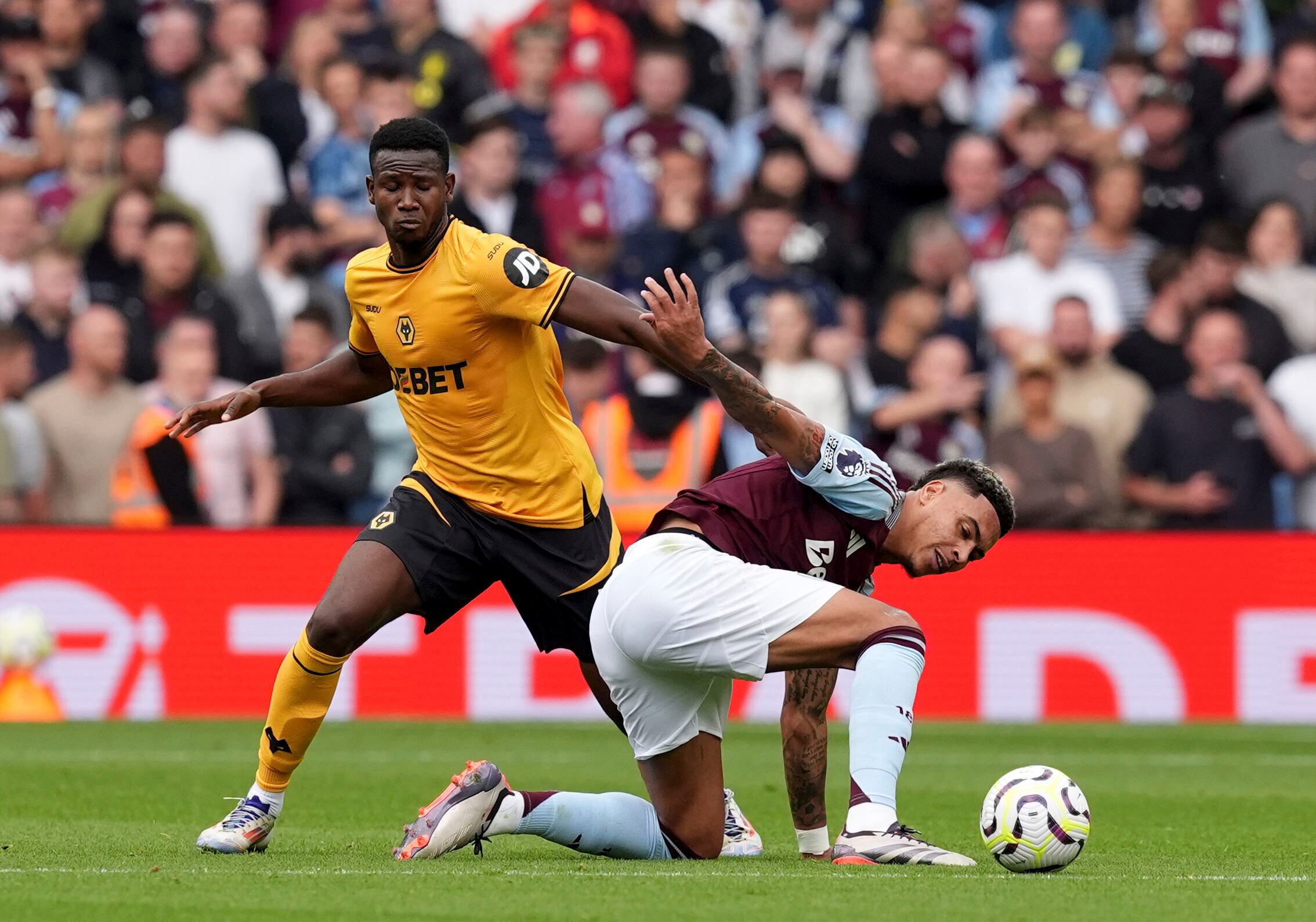 Wolverhampton Wanderers' Yerson Mosquera, left, and Aston Villa's Morgan Rogers in action during the English Premier League soccer match between Aston Villa and Wolverhampton Wanderers at Villa Park, Birmingham, England, Saturday Sept. 21, 2024. (Martin Rickett/PA via AP)