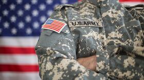 La bandera de Estados Unidos junto a un soldado, en medio del debate sobre el registro automático para el servicio militar.