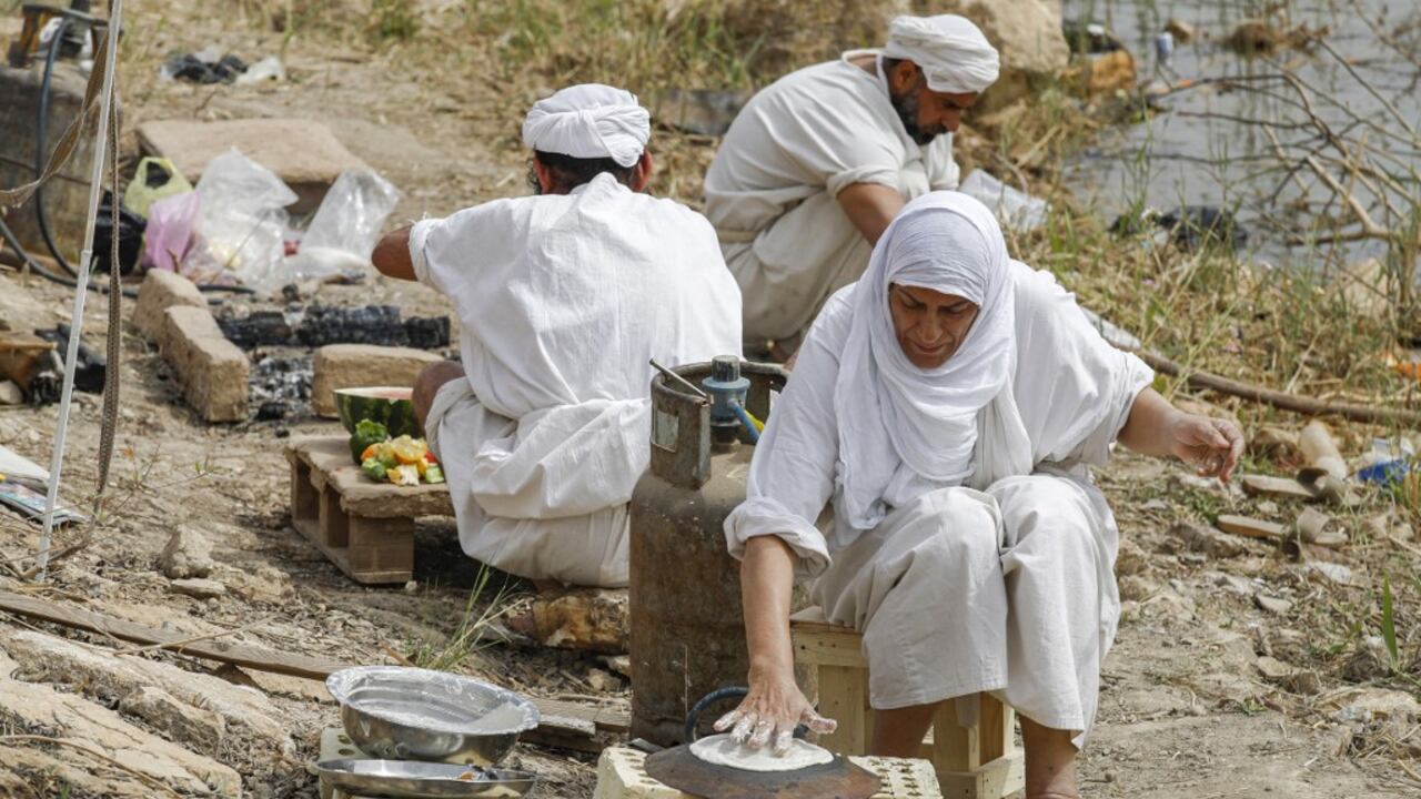 Los seguidores de la fe precristiana de Sabaean, que considera al profeta Abraham como uno de sus fundadores, hornean pan y cocinan a orillas del río Tigris en la capital de Irak, Bagdad, el 15 de marzo de 2022.