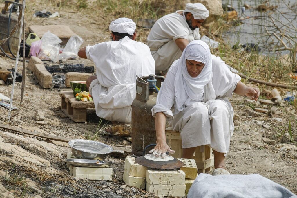 Los seguidores de la fe precristiana de Sabaean, que considera al profeta Abraham como uno de sus fundadores, hornean pan y cocinan a orillas del río Tigris en la capital de Irak, Bagdad, el 15 de marzo de 2022.