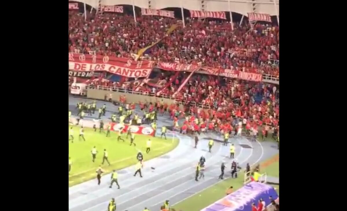 Hinchas de América intentan meterse al gramado del estadio Pascual Guerrero.