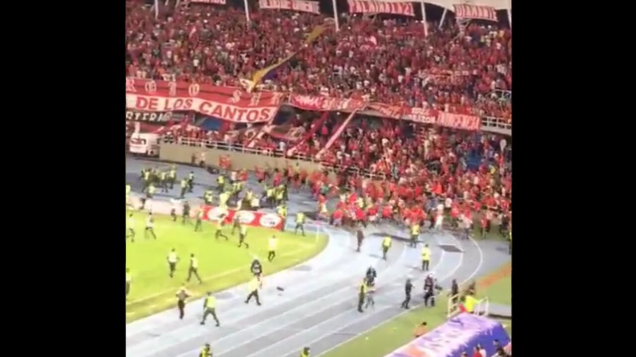Hinchas de América intentan meterse al gramado del estadio Pascual Guerrero.