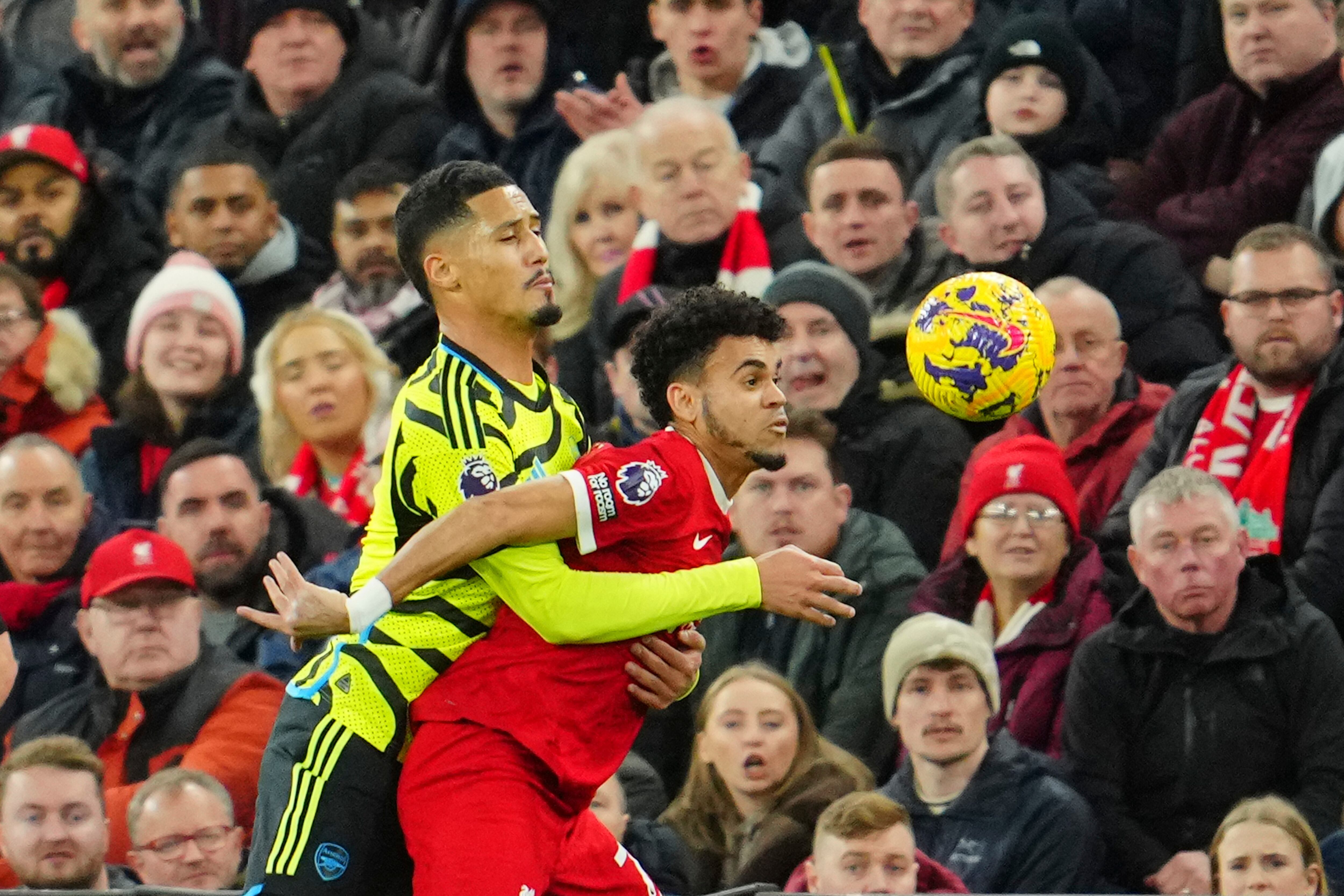 Liverpool's Luis Diaz, right, is challenged by Arsenal's William Saliba during the English Premier League soccer match between Liverpool and Arsenal at Anfield stadium in Liverpool, England, Saturday, Dec. 23, 2023. (AP Photo/Jon Super)