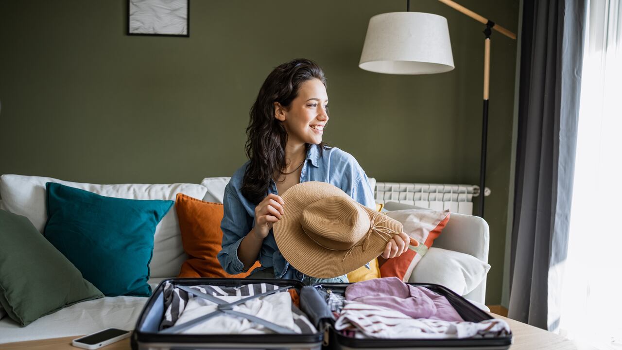 Mujer joven haciendo la maleta para viajar.