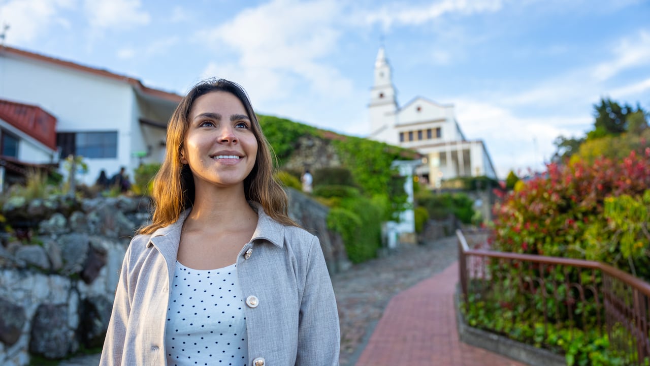 Vista frontal a media altura de una joven turista disfrutando de las vistas del cerro de Monserrate en Bogotá, Colombia