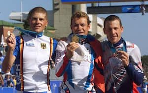 El estadounidense Lance Arsmtrong (D) exhibe la medalla de bronce de la prueba contrarreloj de los Juegos Olímpicos de Sídney-2000, conjuntamente con el ruso Viacheslav Ekimov (C), medalla de oro, y el alemán Jan Ullrich (I), bronce, el 30 de setiembre de 2000 en Sídney