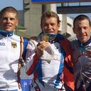 El estadounidense Lance Arsmtrong (D) exhibe la medalla de bronce de la prueba contrarreloj de los Juegos Olímpicos de Sídney-2000, conjuntamente con el ruso Viacheslav Ekimov (C), medalla de oro, y el alemán Jan Ullrich (I), bronce, el 30 de setiembre de 2000 en Sídney