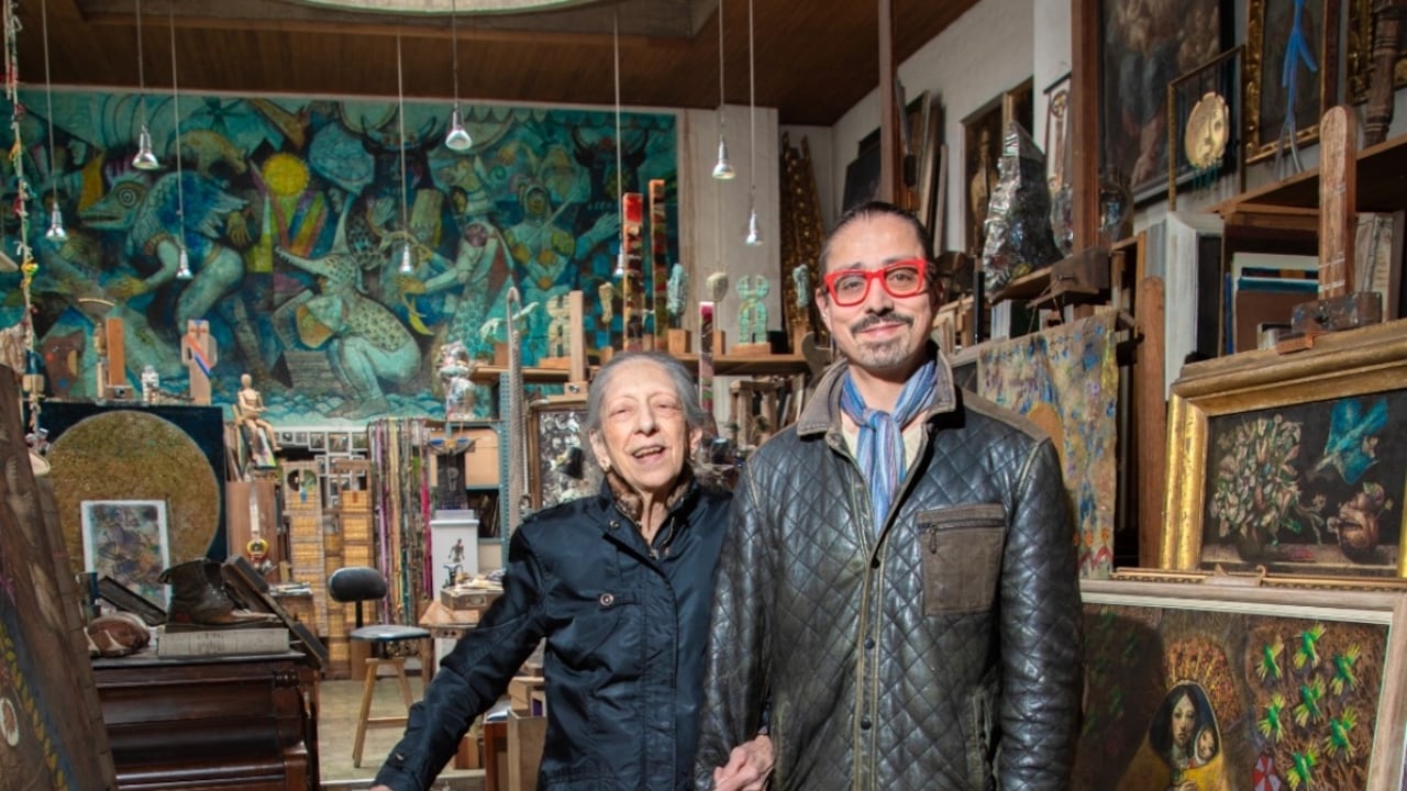 Sonia Guerrero y Daniel Villegas, viuda e hijo del maestro, en su taller en Bogotá. El montaje de la exposición buscará recrear la atmósfera del lugar, con abundancia de cuadros colgados desde el techo y obras tridimensionales.