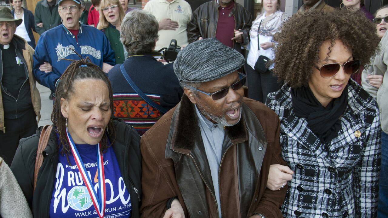 Aun cuando Rachel Dolezal (chaqueta a cuadros) ha modelado su físico para parecer negra, las fotos de infancia reveladas por sus padres muestran a una niña blanca y de ojos claros. Ella dice que siempre se ha sentido negra y que tiene derecho a ello.