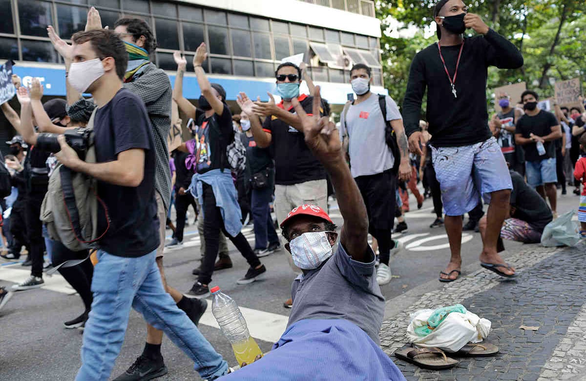 Un hombre en la calle hace una señal de victoria y se une al grito de protesta de los brasileños. Foto: Silvia Izquierdo /AP.