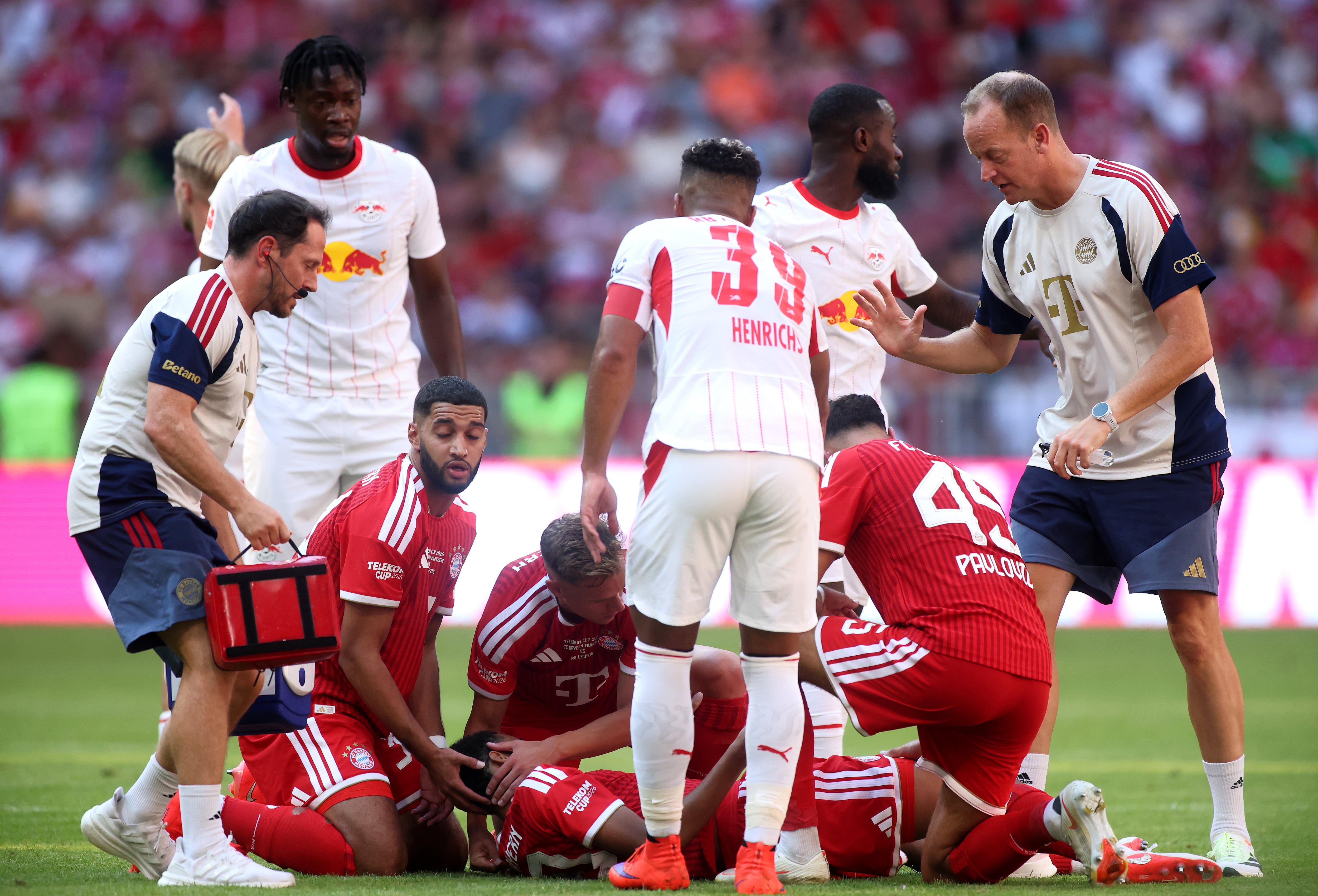 MUNICH, GERMANY - AUGUST 15: Jamal Musiala of Bayern Munich receives medical attention after sustaining an injury during the Telekom Cup match between FC Bayern München and RB Leipzig at Allianz Arena on August 15, 2026 in Munich, Germany. (Photo by Alex Grimm/Getty Images)