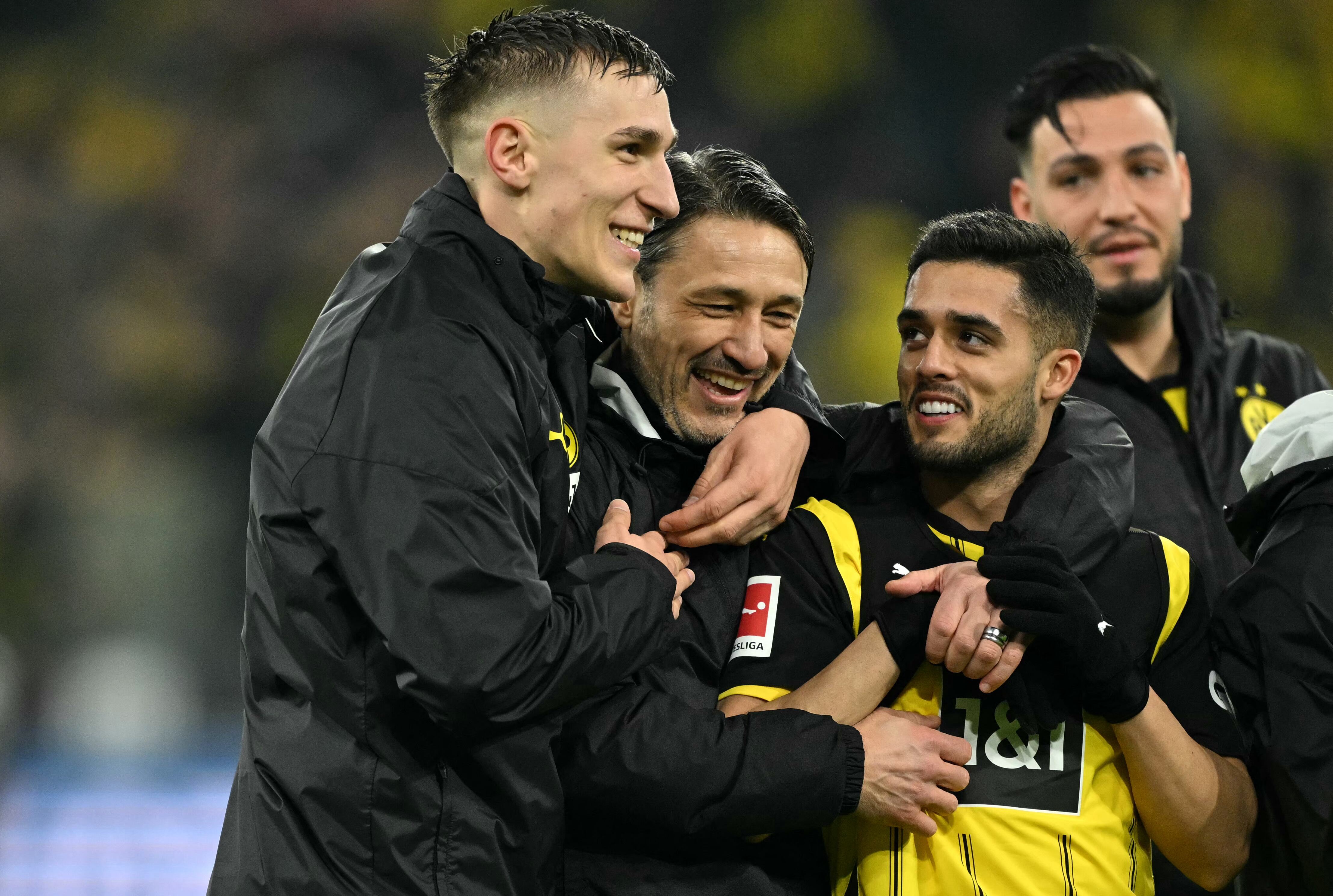 El defensor alemán #04 del Dortmund, Nico Schlotterbeck (izq.), el entrenador croata del Dortmund, Niko Kovac (2.º izq.) y el defensor brasileño #02 del Dortmund, Yan Couto (3.º izq.), celebran después del partido de fútbol de la primera división alemana, la Bundesliga, entre el BVB Borussia Dortmund y el 1 FC Union Berlin en Dortmund, Alemania occidental, el 22 de febrero de 2025.