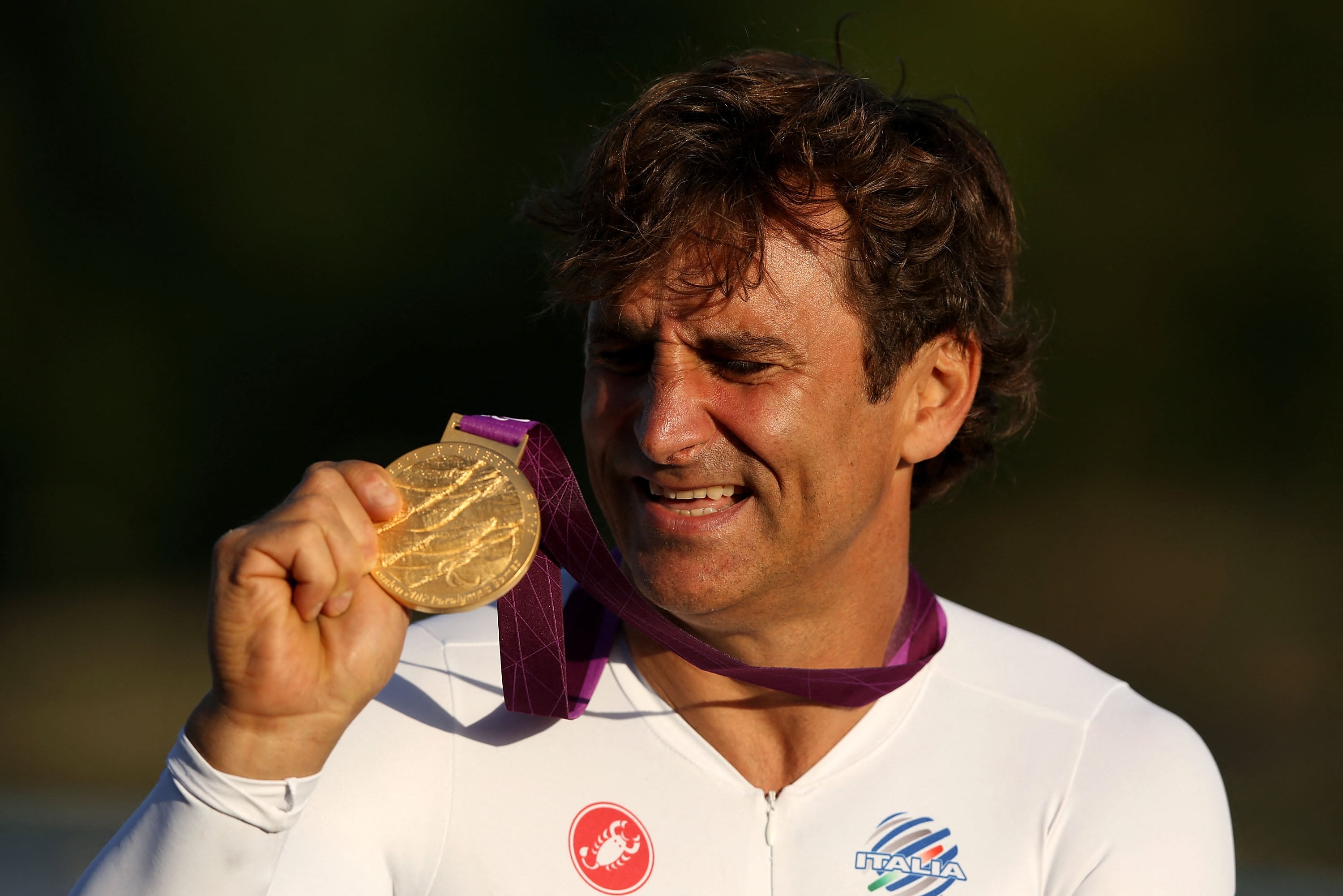 LONGFIELD, ENGLAND - SEPTEMBER 05: Alessandro Zanardi of Italy reacts on the podium after winning the Men's Individual H4 Time Trialon day 7 of the London 2012 Paralympic Games at Brands Hatch on September 5, 2012 in Longfield, England. (Photo by Clive Rose/Getty Images) (Photo by CLIVE ROSE / GETTY IMAGES EUROPE / Getty Images via AFP)
