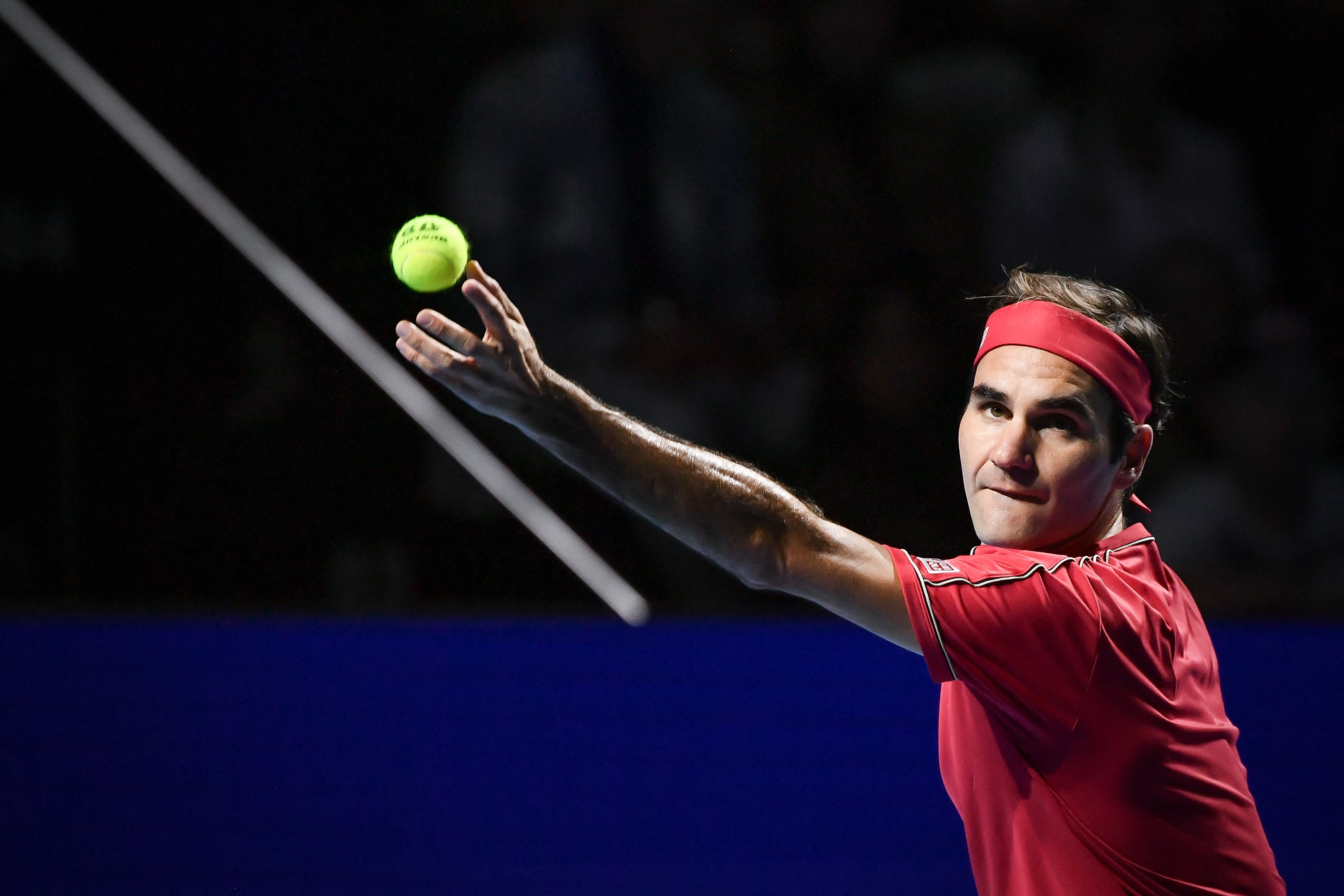 (FILES) In this file photo taken on October 27, 2019 Swiss Roger Federer serves a ball to Australian Alex De Minaur during their final match at the Swiss Indoors tennis tournament in Basel. - Former men's tennis world number one Roger Federer, plagued by recurring knee problems for the last two years, is to return to the ATP circuit at the Basel indoor tournament in October, organisers announced on April 26, 2022. (Photo by FABRICE COFFRINI / AFP)