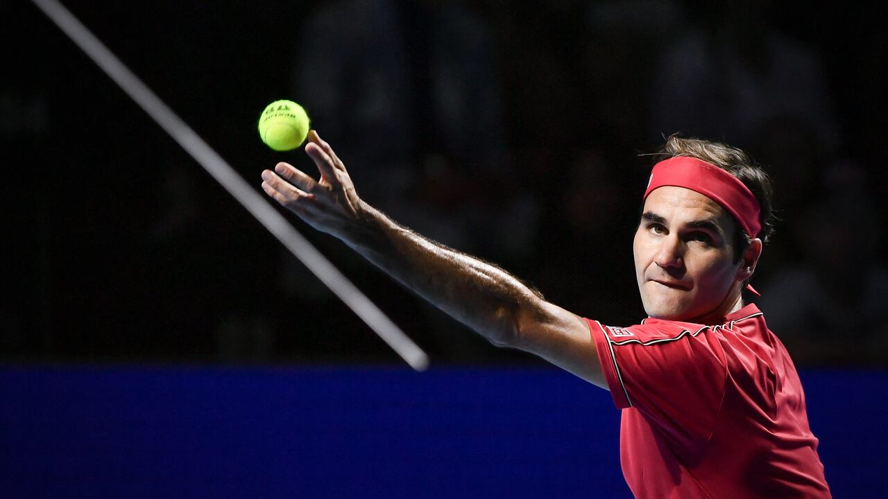 (FILES) In this file photo taken on October 27, 2019 Swiss Roger Federer serves a ball to Australian Alex De Minaur during their final match at the Swiss Indoors tennis tournament in Basel. - Former men's tennis world number one Roger Federer, plagued by recurring knee problems for the last two years, is to return to the ATP circuit at the Basel indoor tournament in October, organisers announced on April 26, 2022. (Photo by FABRICE COFFRINI / AFP)