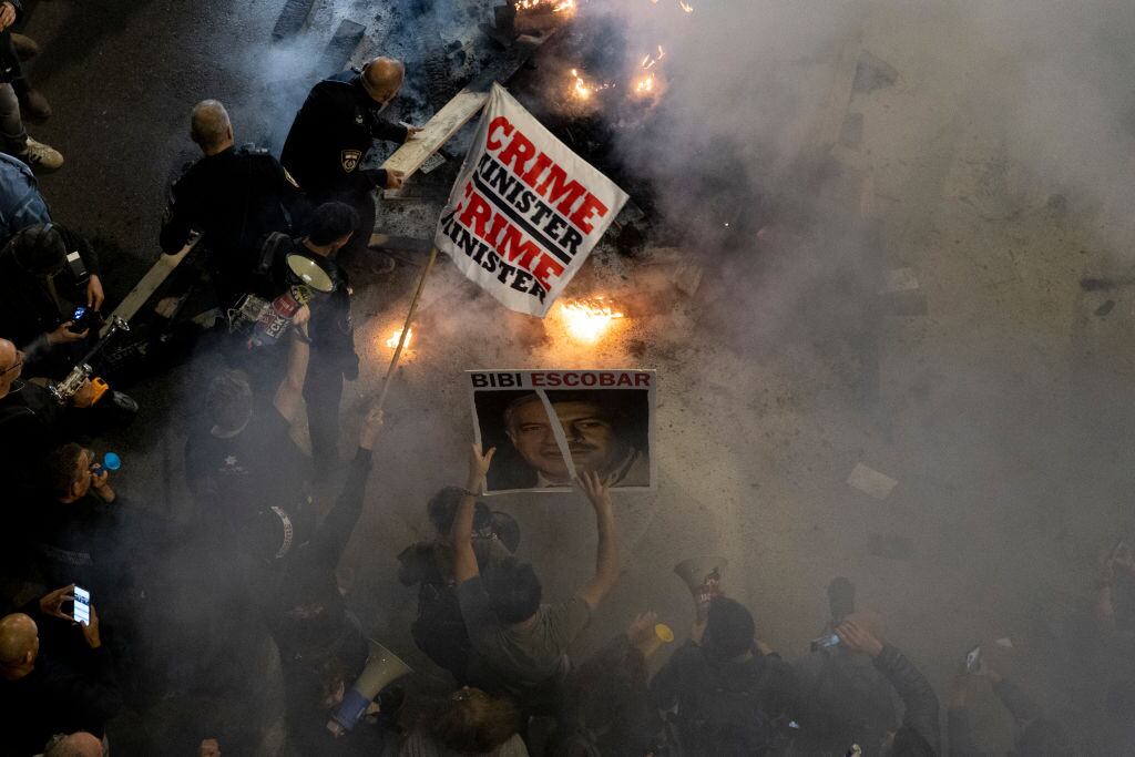 Agentes de policía distinguen un incendio durante una protesta por la liberación de todos los rehenes y contra el primer ministro israelí Benjamin Netanyahu y su gobierno el 16 de marzo de 2024 en Tel Aviv, Israel.