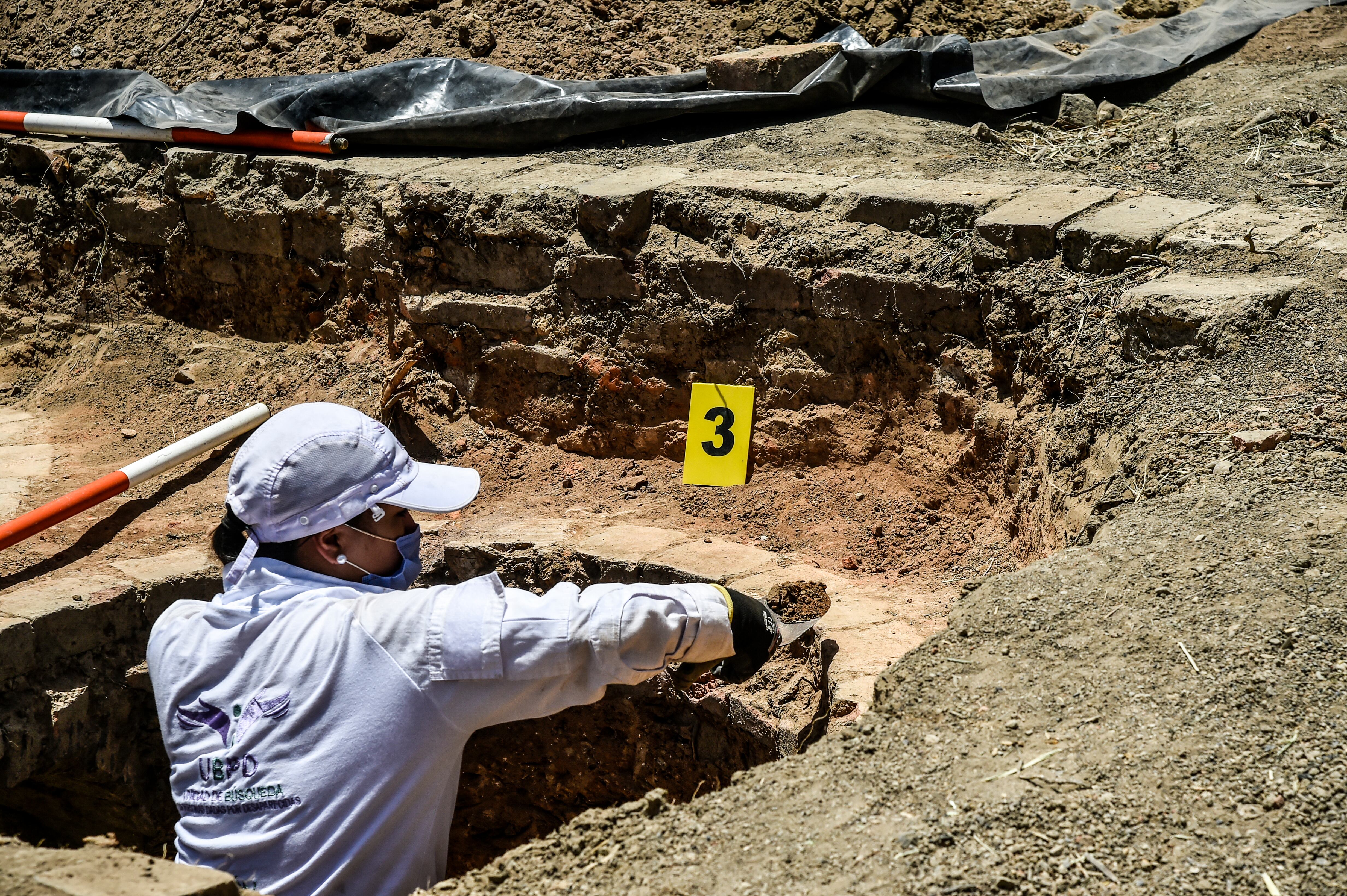 Un médico forense revisa una cámara crematoria donde grupos paramilitares desaparecieron a sus víctimas durante el conflicto armado, en la zona de Juan Frío en el municipio de Villa del Rosario