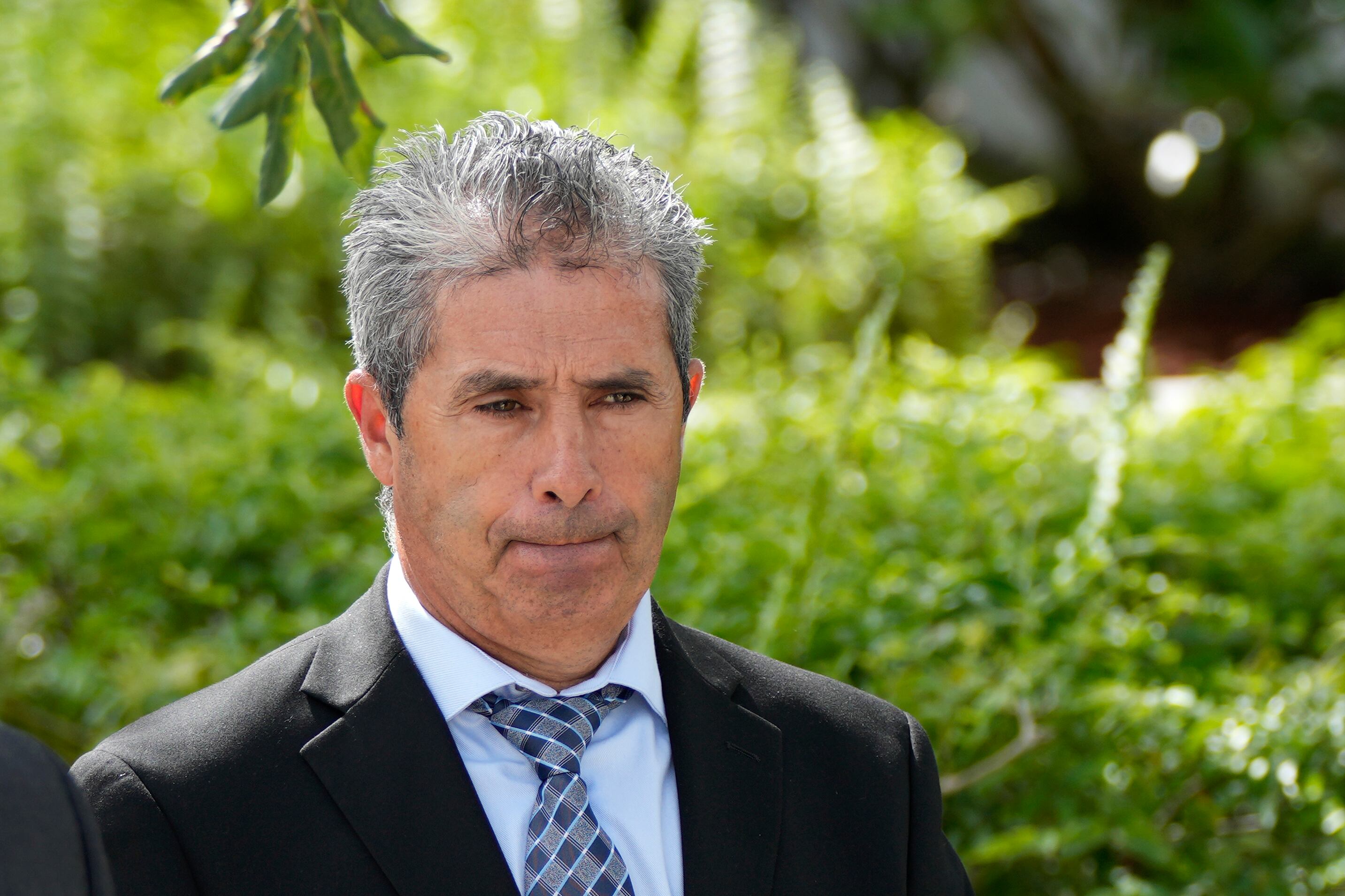 Carlos De Oliveira, centro, administrador de la propiedad Mar-a-Lago del expresidente Donald Trump, sale del juzgado de EE. UU. Alto Lee Adams Sr. luego de su audiencia de lectura de cargos