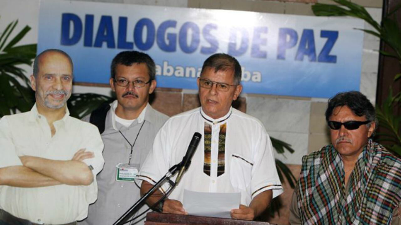 El comandante de la guerrilla de las FARC Ricardo Téllez, alias "Rodrigo Granda", lee un comunicado junto a los guerrilleros Seuxis Paucias Hernández Solarte, alias "Jesús Santrich" (i), y Yuri Camargo (i), quien sostiene una imagen en cartón de su compañero Ricardo Palmera, alias 'Simón Trinidad'.