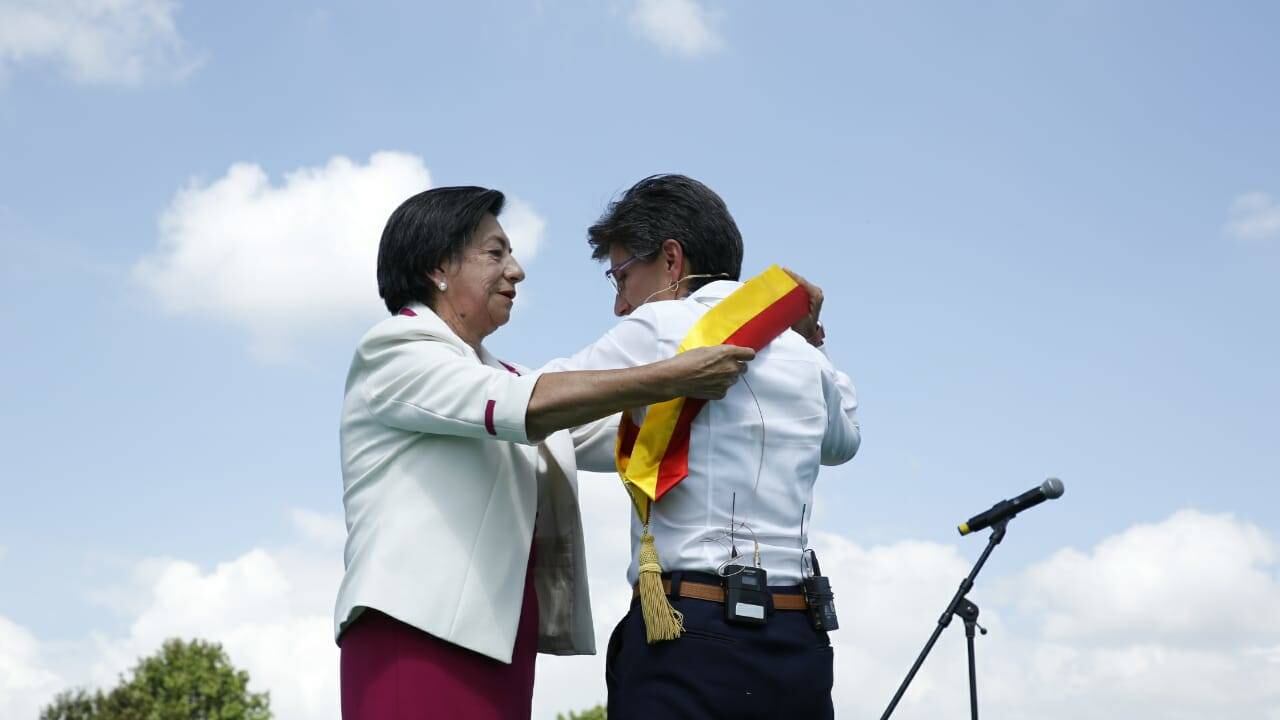 María del Carmen Hernández poniéndole a su hija la banda de alcaldesa de Bogotá.