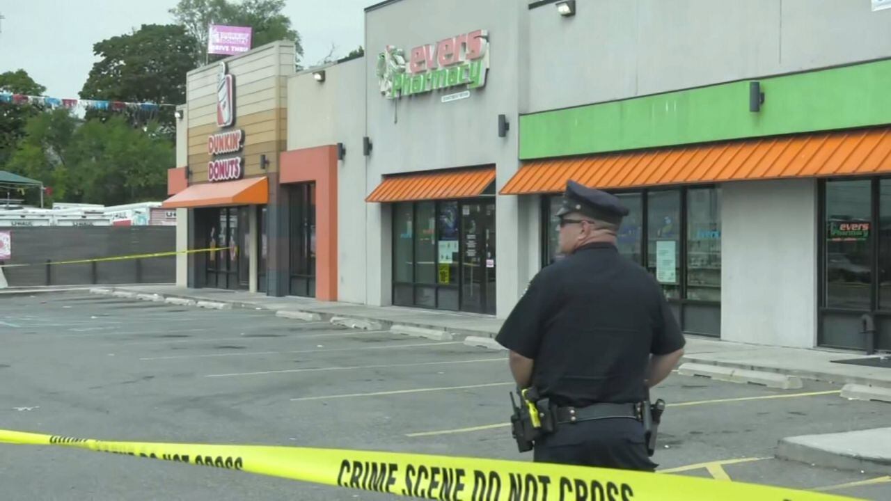 Escena policial con patrullas y cinta amarilla frente a un Dunkin’ Donuts en Queens tras un tiroteo.