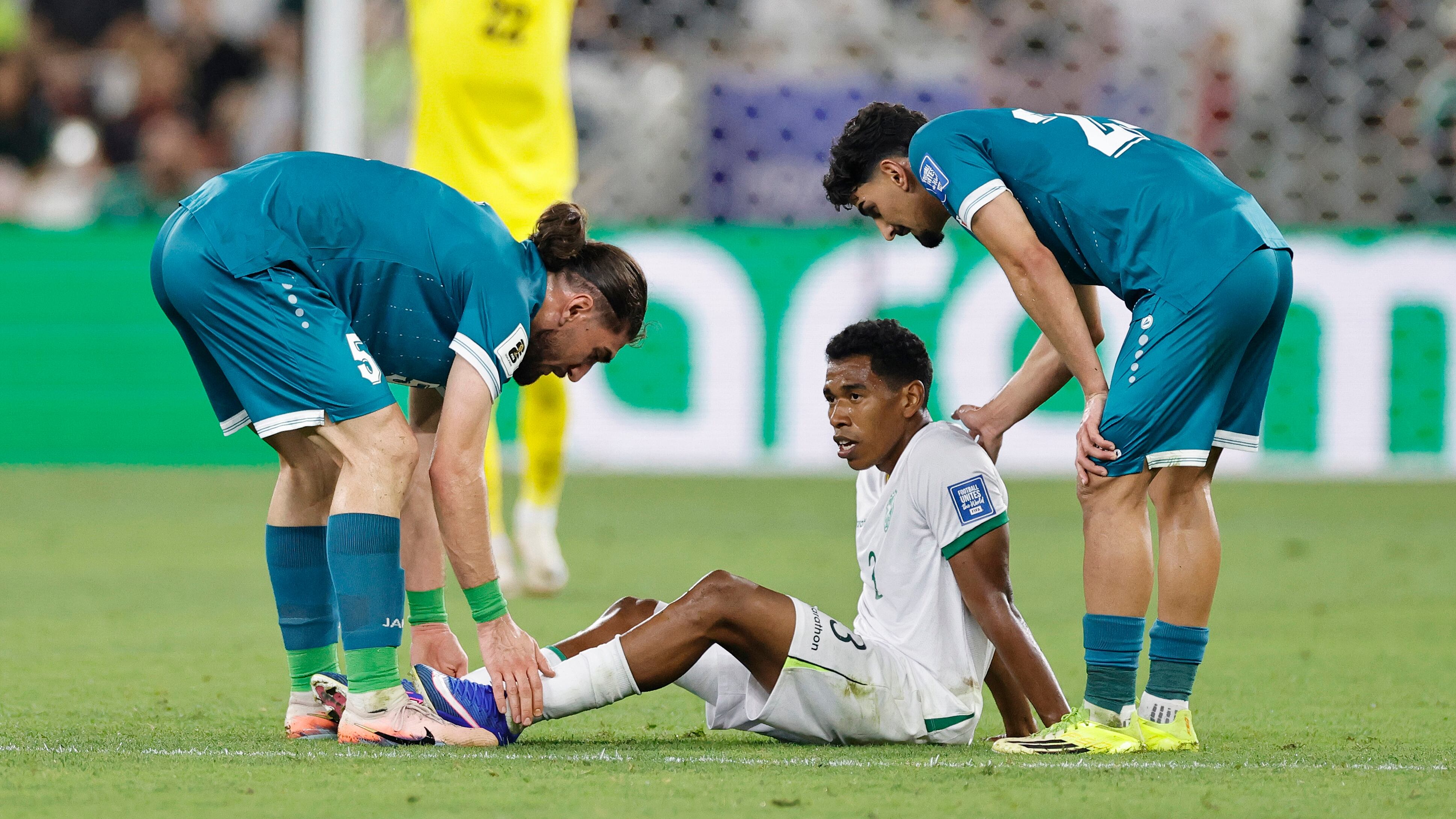 Jugadores de Irak consuelan a Diego Medina, de Bolivia.
