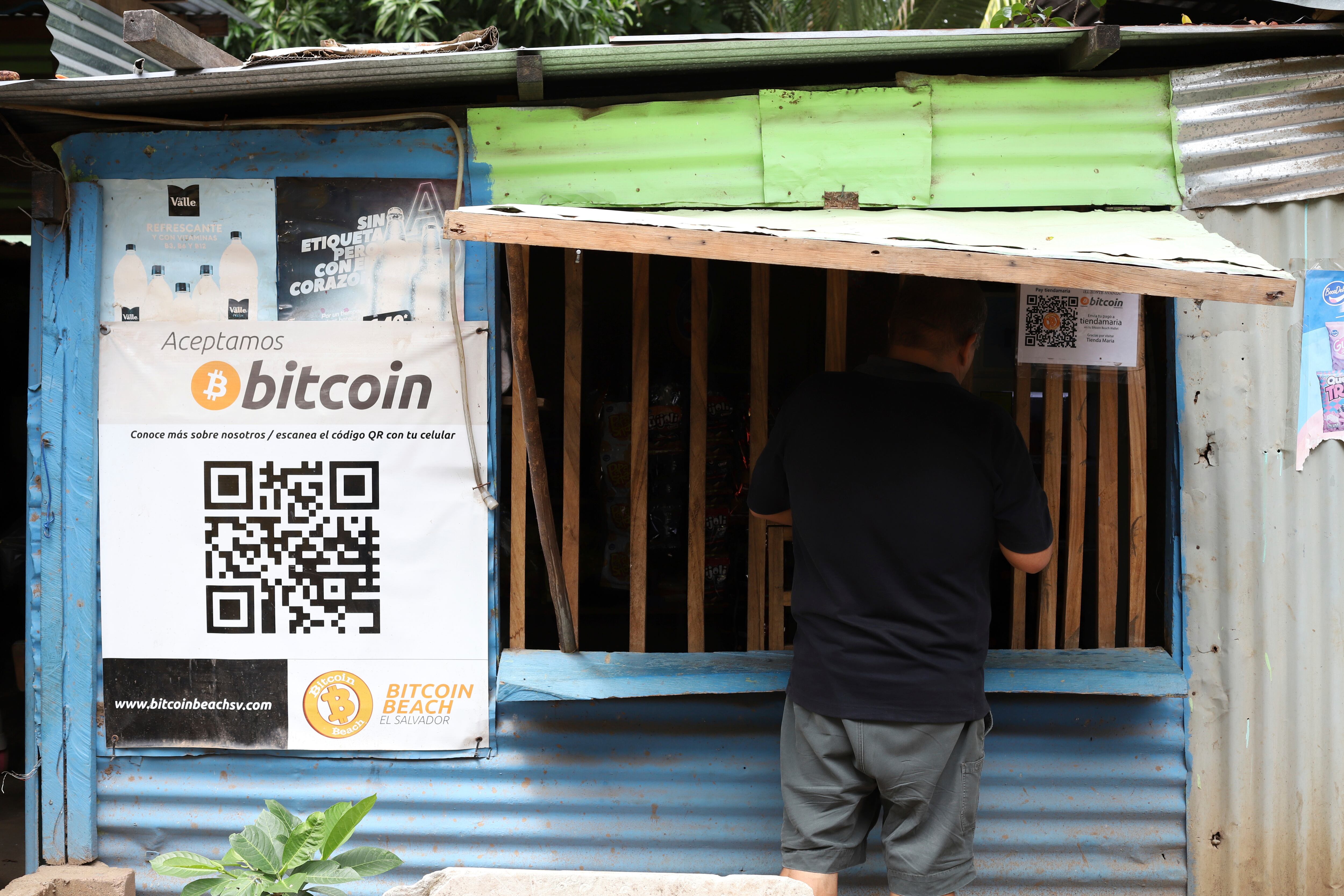 Un trabajador de Hope House, una organización que patrocina el uso de criptomonedas en la playa El Zonte, realiza una compra en una pequeña tienda que acepta Bitcoin, en Tamanique, El Salvador. (AP Foto/Salvador Meléndez)