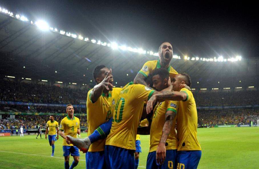 El brasileño Dani Alves salta sobre sus compañeros de equipo luego de que su Gabriel Jesús anotara el primer gol de su equipo contra Argentina durante la semifinal de la Copa América en el Estadio Mineirao, en Belo Horizonte, Brasil, el martes 2 de julio de 2019. (Foto AP / Eugenio Savio)