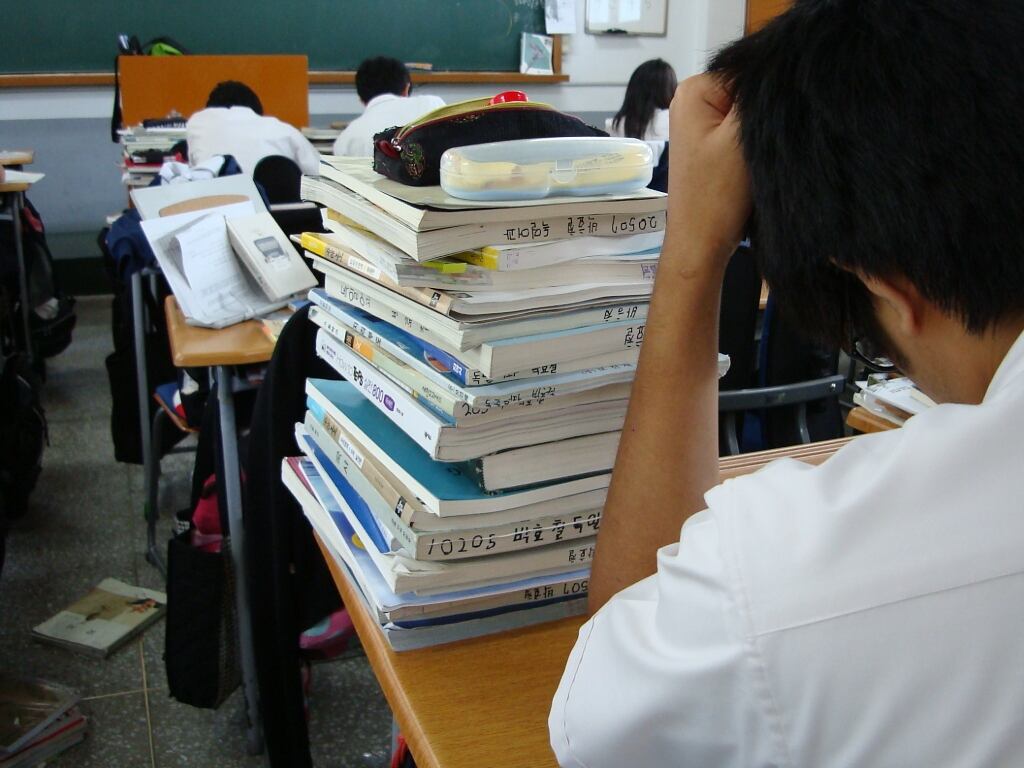 Fotografía de la mesa de un estudiante coreano a principios de los 2000 cursando el último año de instituto, con un tercio de los libros que tiene que estudiar sobre la mesa. Jens-Olaf Walter / Flickr, CC BY-SA
