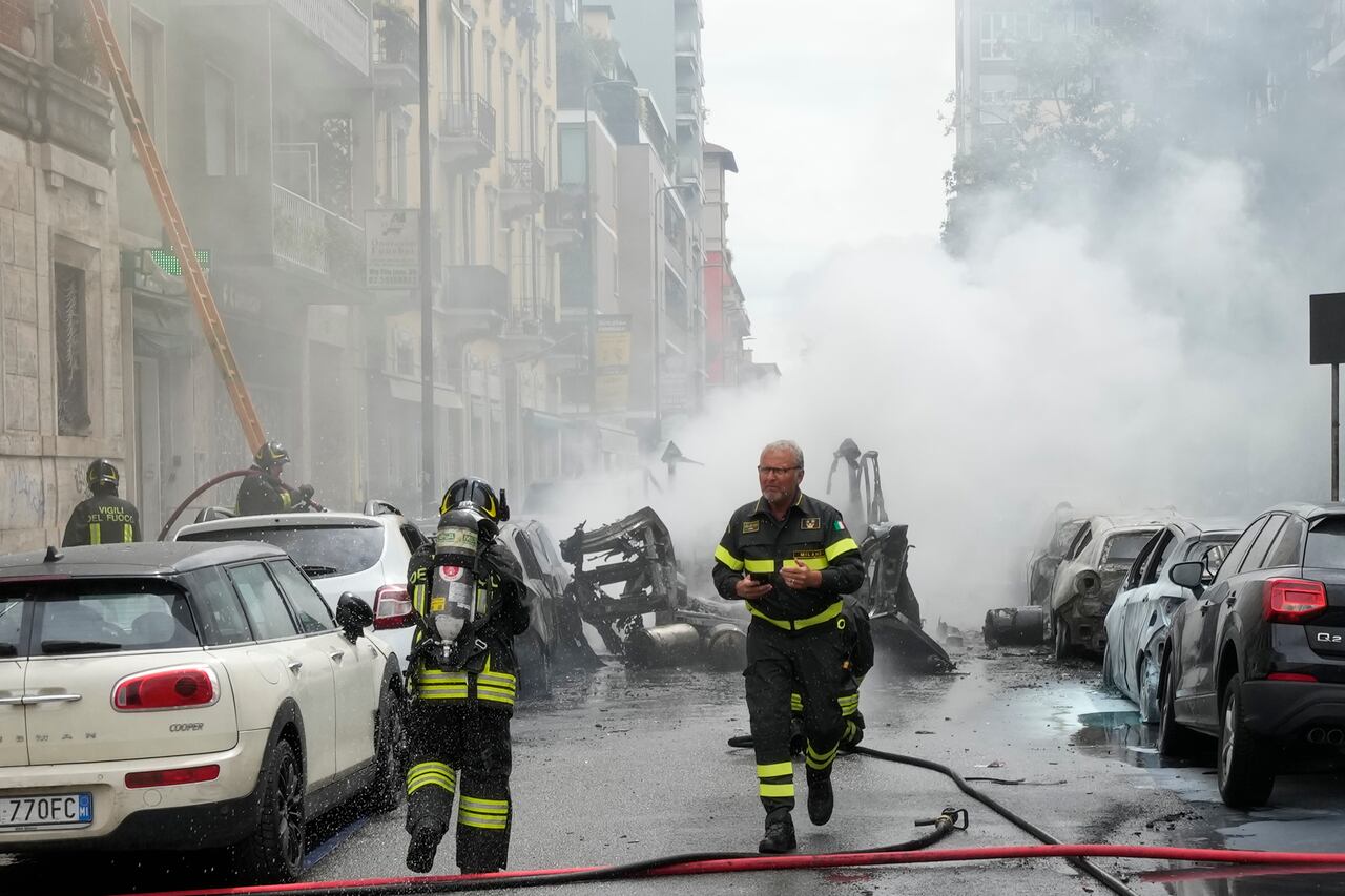 Los bomberos trabajan para extinguir un incendio en un edificio luego de que el camión explotara en el centro de Milán.