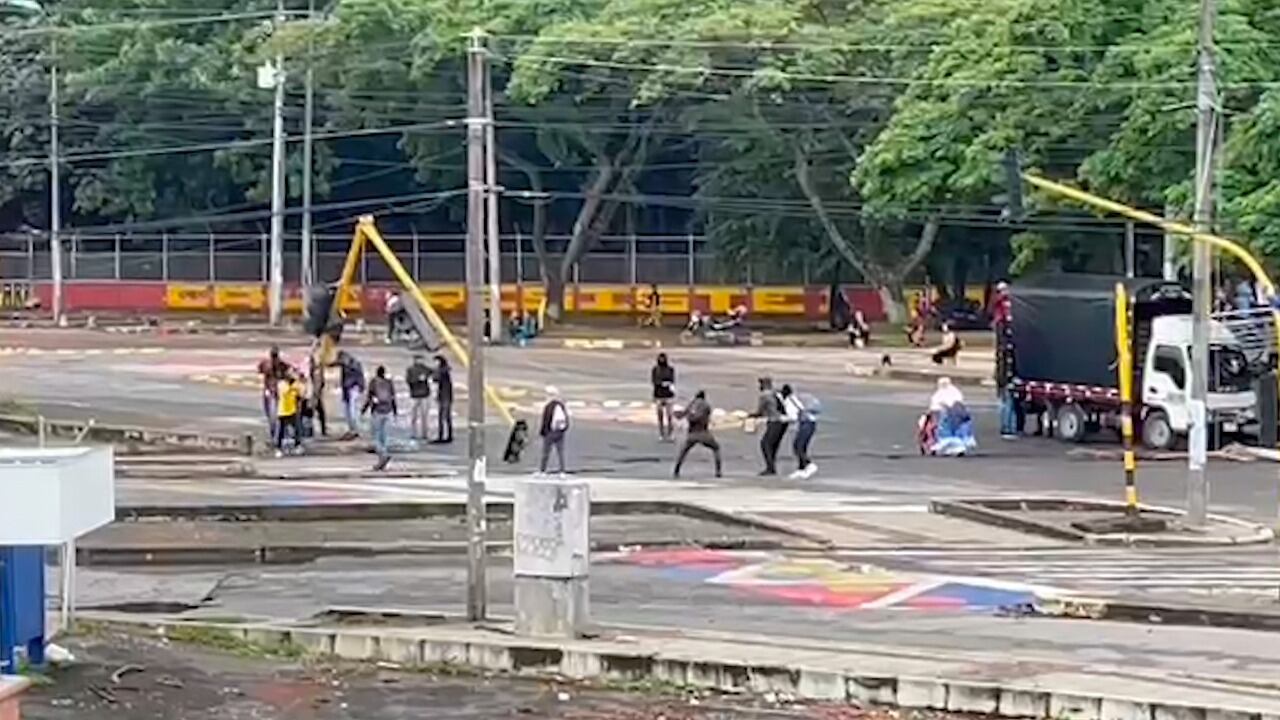 Un grupo de encapuchados tratan de derribar un semáforo en una de las entradas de Ciudad Jardín, en Cali.