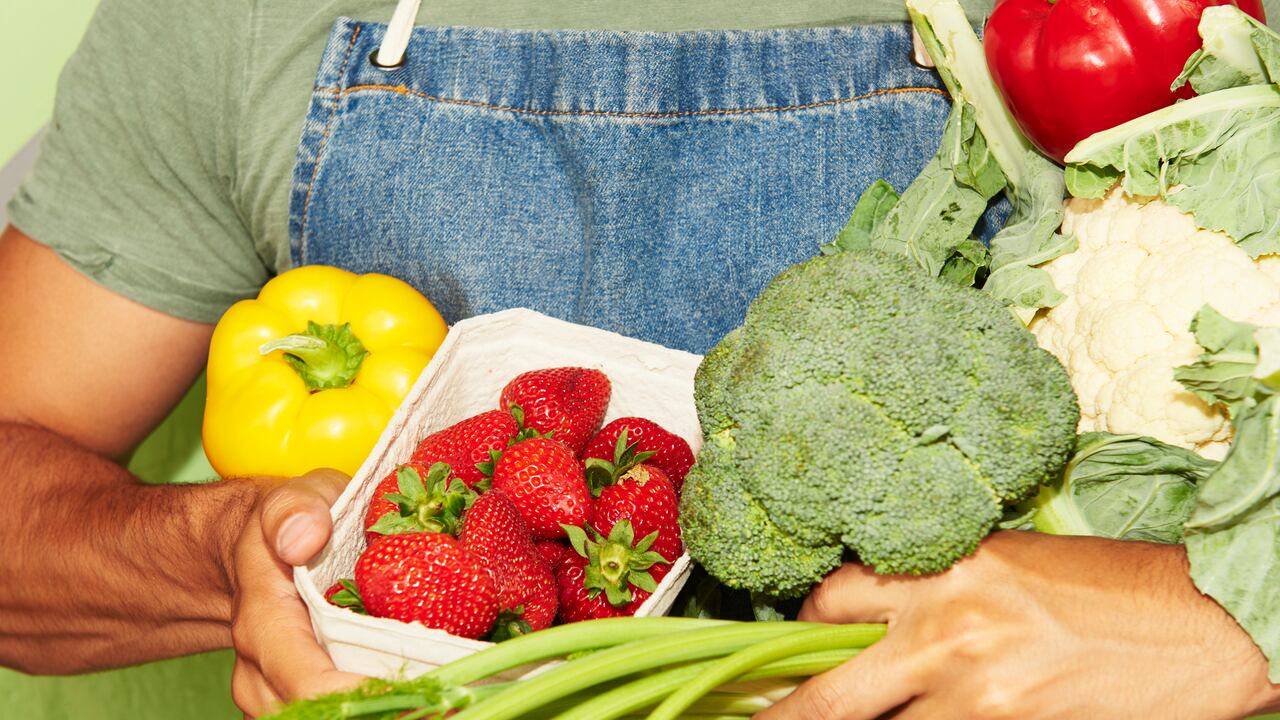 Hombre soportando vegetales frescos