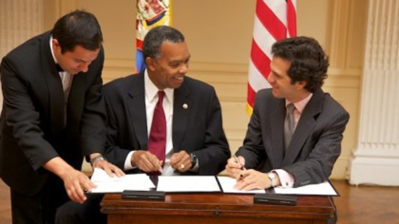 El director de los Cuerpos de Paz, Aaron Williams, y el canciller colombiano, Jaime Bermúdez, cuando firmaban este martes en Washington el convenio del regreso a Colombia de los jóvenes voluntarios de EE.UU.