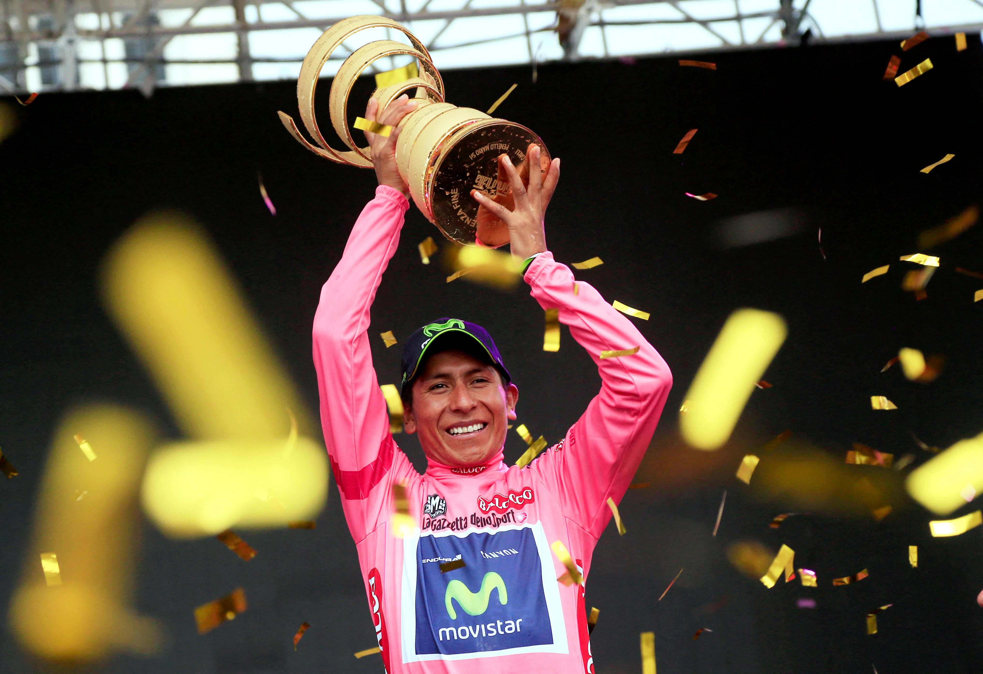 El colombiano Nairo Quintana celebra en el podio con el trofeo y el maillot rosa de líder de la clasificación general, tras ganar la 97ª carrera ciclista del Giro de Italia, al final de la 21ª y última etapa, a 172 kilómetros de Gemona. a Trieste, el 1 de junio de 2014 en Trieste. AFP PHOTO/LUK BENIES (Foto de LUK BENIES / AFP)