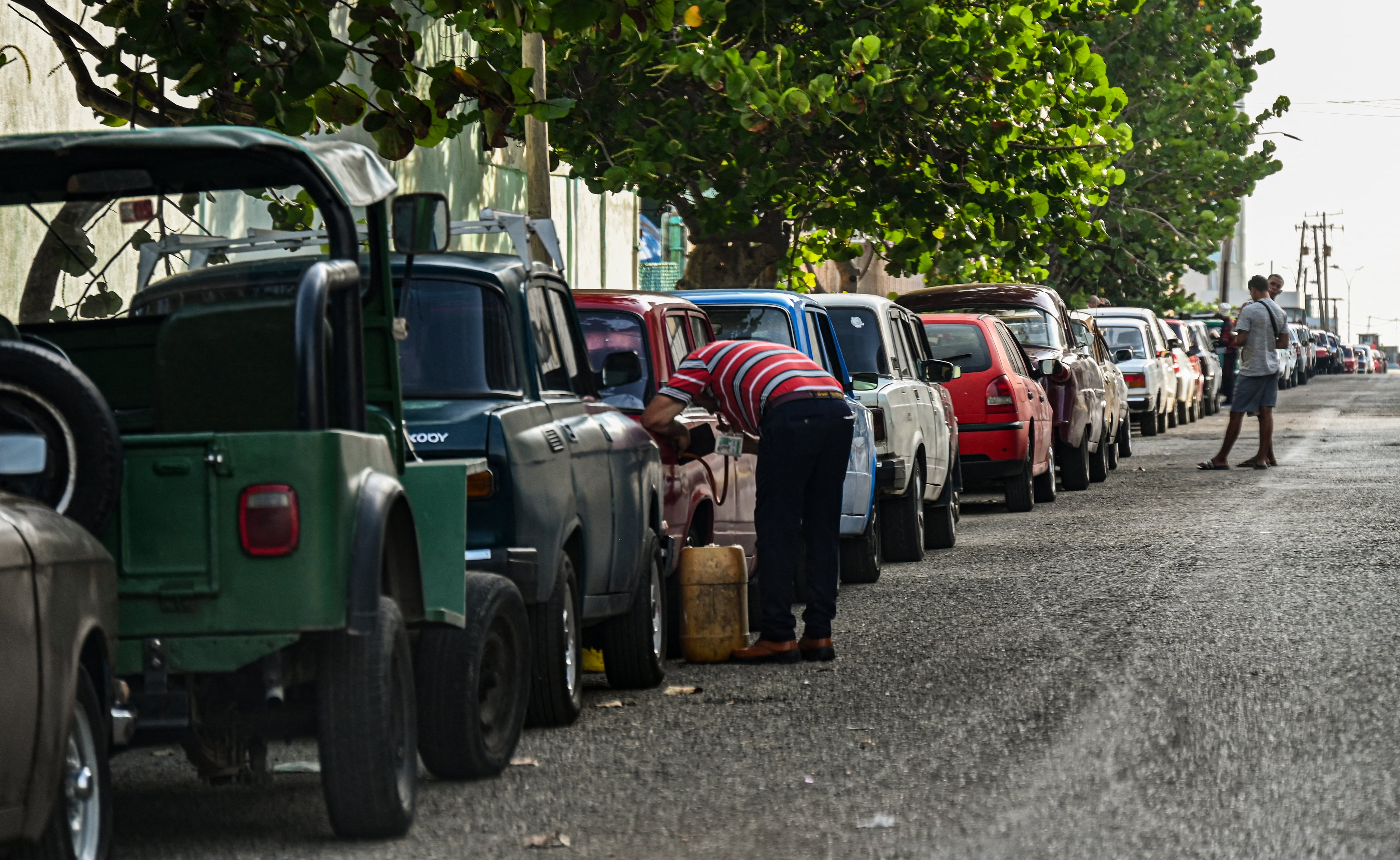 Conductores hacen cola para cargar combustible cerca de una gasolinera en La Habana el 24 de abril de 2023. - "¡Esto es un infierno!" exclama Lázaro Díaz, un mensajero cubano de 59 años que hace cola desde hace un día con la esperanza de conseguir gasolina, en la crisis de escasez de combustible más larga que los habaneros dicen haber vivido en años. (Foto de YAMIL LAGE / AFP)