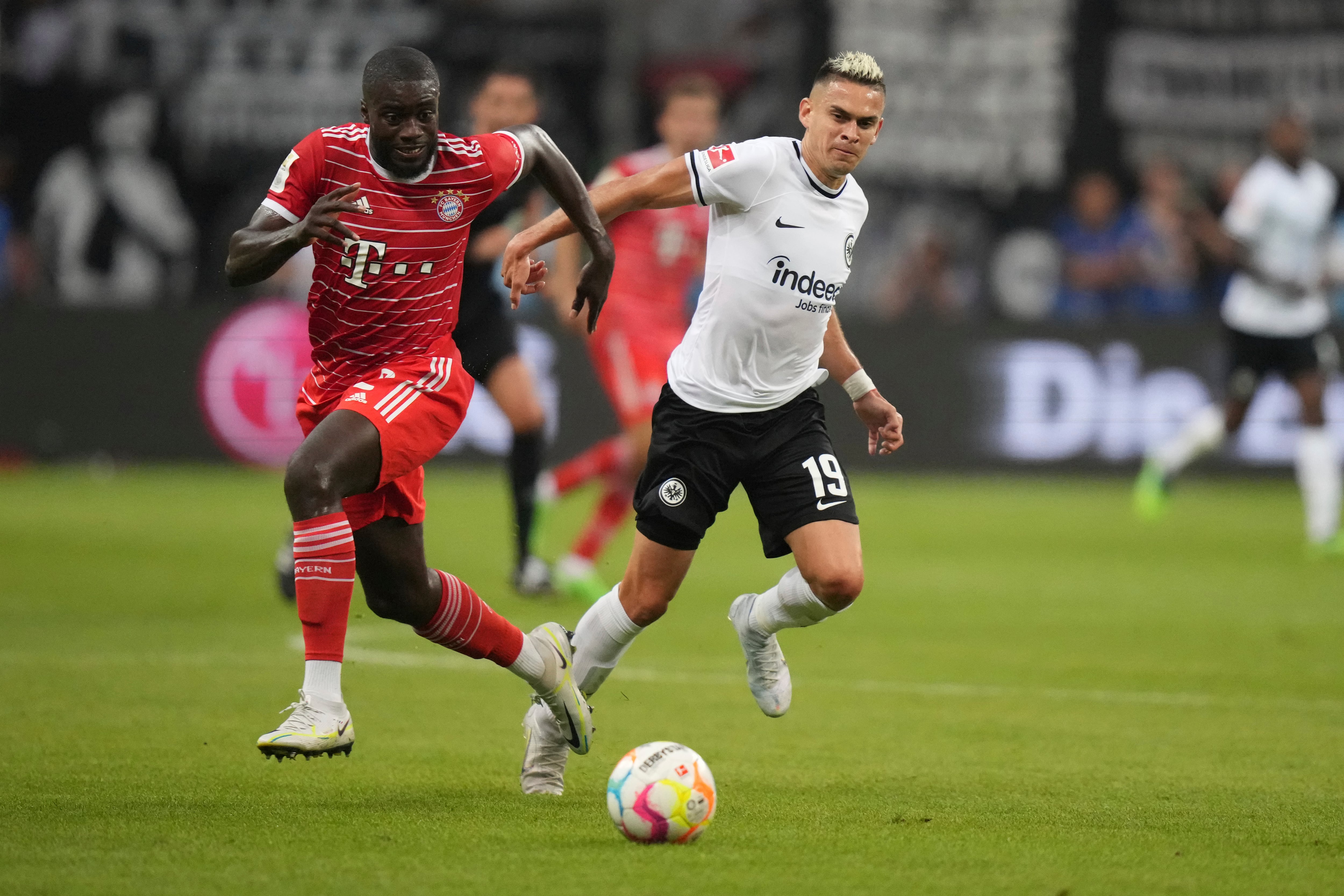Frankfurt's Rafael Santos Borre Maury, right, and Bayern's Dayot Upamecano challenge for the ball in a fog of pyrotechnics set off by Frankfurt's fans during the German Bundesliga soccer match between Eintracht Frankfurt and Bayern Munich in Frankfurt, Germany, Friday, Aug. 5, 2022. (AP Photo/Matthias Schrader)