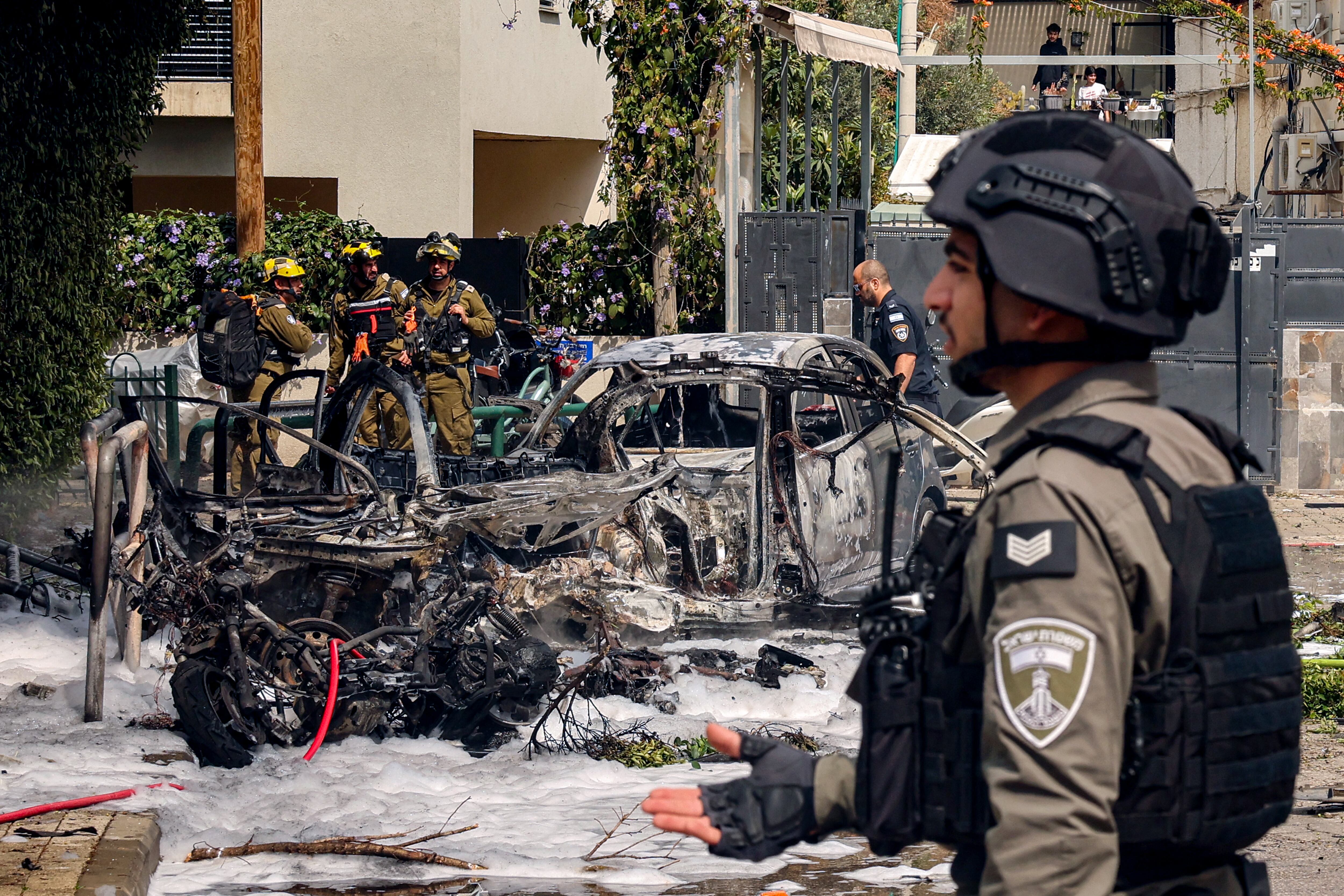Soldados del ejército israelí y guardias fronterizos se congregan en el lugar del impacto de un proyectil procedente de un ataque iraní en el sur de Tel Aviv el 15 de marzo de 2026.