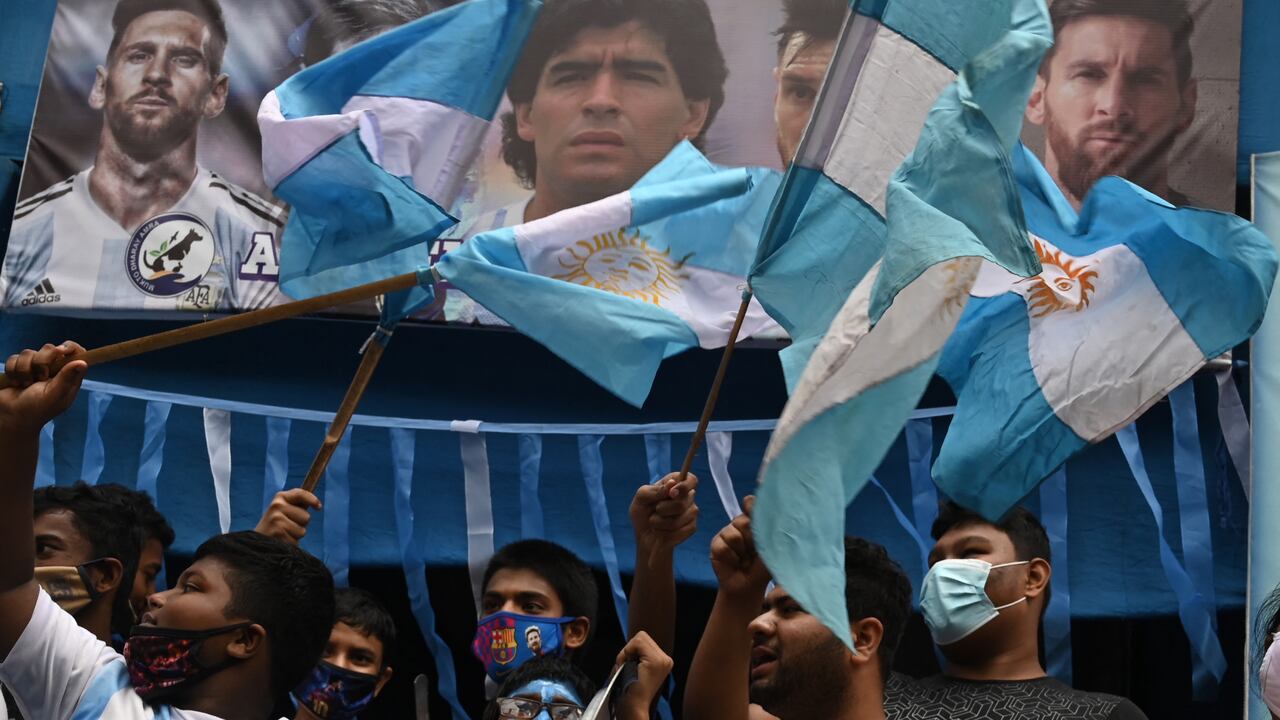 Fans of Argentina hold national flags as they celebrate after winning the Conmebol 2021 Copa America football tournament final match against Brazil, in Kolkata on July 11, 2021. (Photo by DIBYANGSHU SARKAR / AFP)