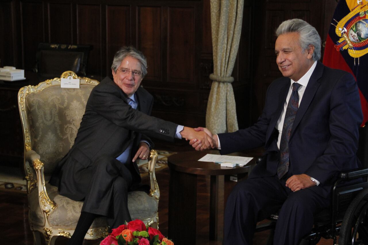 El recién elegido presidente de Ecuador, Guillermo Lasso (izq.), saluda al presidente saliente Lenín Moreno Garcés durante una reunión en el Palacio de Carondelet el 19 de abril de 2021 en Quito, Ecuador.