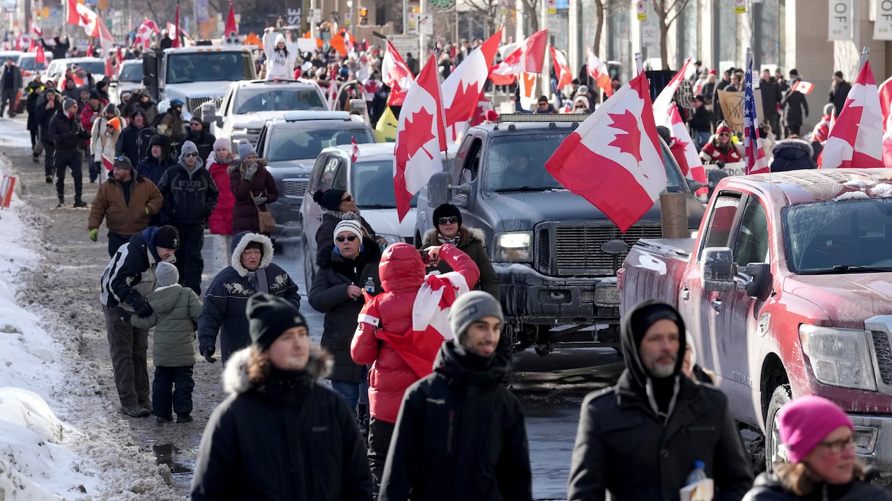 Camiones y simpatizantes viajan por Bloor Street durante una manifestación en apoyo de un convoy de camioneros en Ottawa que protesta por las restricciones del coronavirus.