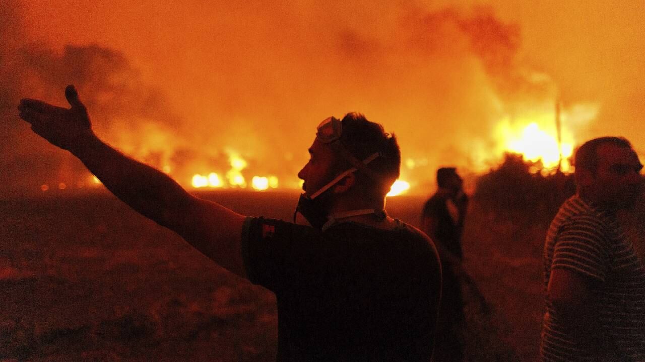 Pobladores intentan extinguir un incendio forestal en la aldea de Avantas, en Grecia.