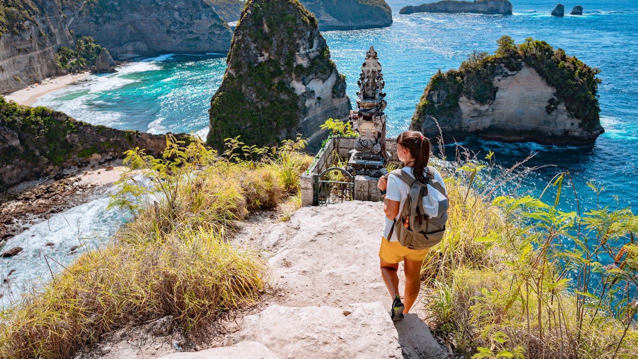 Turista mirando la playa Diamond desde arriba, Nusa Penida, Indonesia
