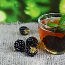 Blackberry tea with fresh picked blackberries in a glass cup on a burlap cloth background.Healthy drink,diet,alternative therapy or herbal medicine concept.