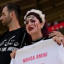 An Iran supporter, right, cries as she holds a shirt that reads 'Mahsa Amini' an Iranian woman who died while in police custody in Iran, prior to the start of the World Cup group B soccer match between Wales and Iran, at the Ahmad Bin Ali Stadium in Al Rayyan, Qatar, Friday, Nov. 25, 2022. (AP Photo/Alessandra Tarantino)