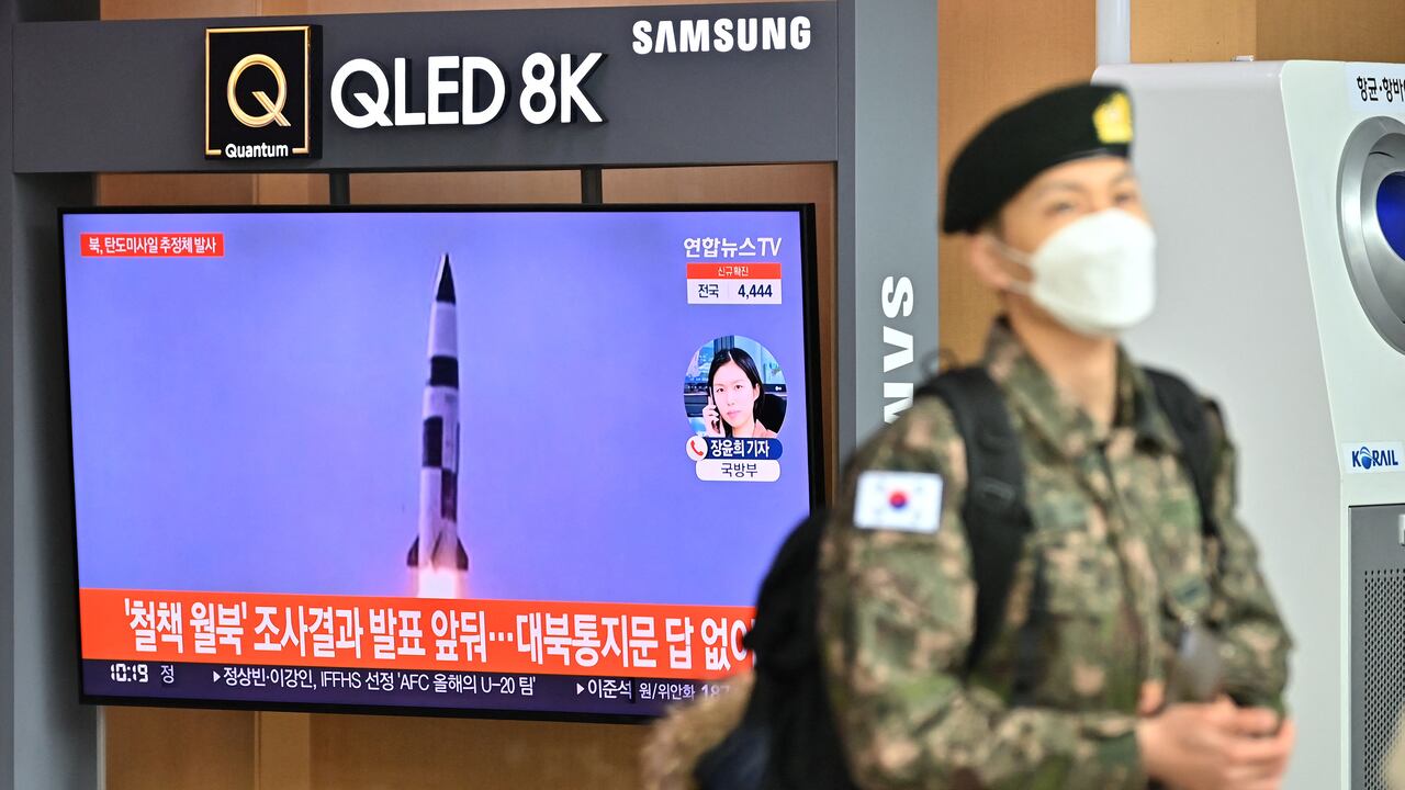 Un soldado surcoreano pasa junto a una pantalla de noticias de televisión que muestra imágenes de archivo de una prueba de misiles de Corea del Norte, en una estación de tren en Seúl el 5 de enero de 2022(Photo by Jung Yeon-je / AFP)