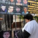 Una mujer mira la foto de su hijo, en la Plaza Central de Soacha.